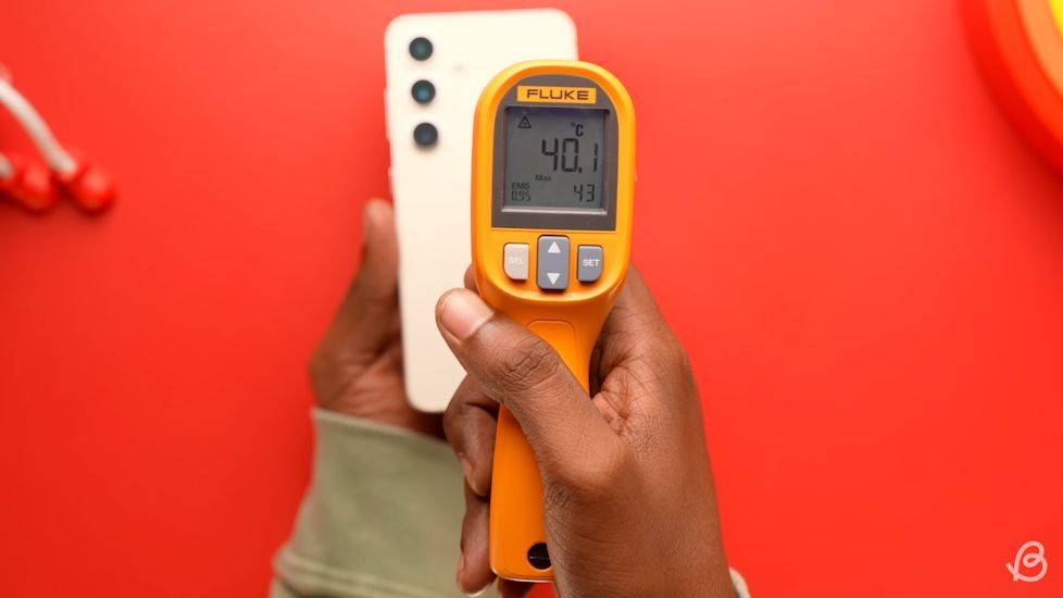 Person pointing a temperature gun at a Samsung phone