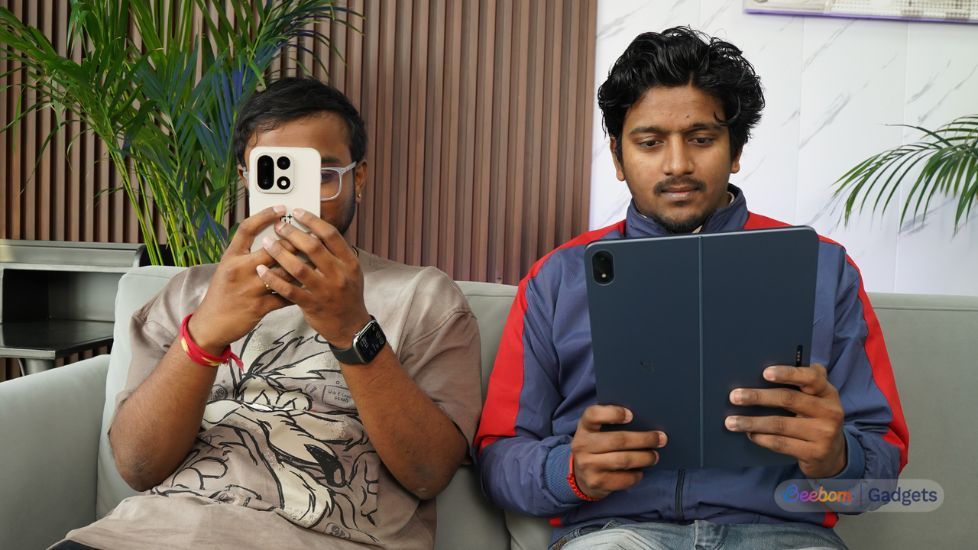 Persons holding OnePlus 15 and tablet Persons holding OnePlus 15 and tablet
