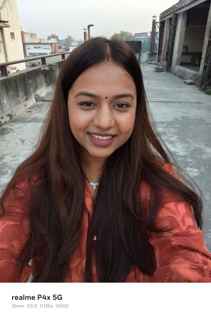 Realme P4x selfie photo of a person wearing an orange dress Realme P4x selfie photo of a person wearing an orange dress