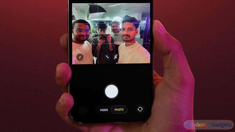 iPhone 17 iin hand with front camera set to 16:9 and people in the frame