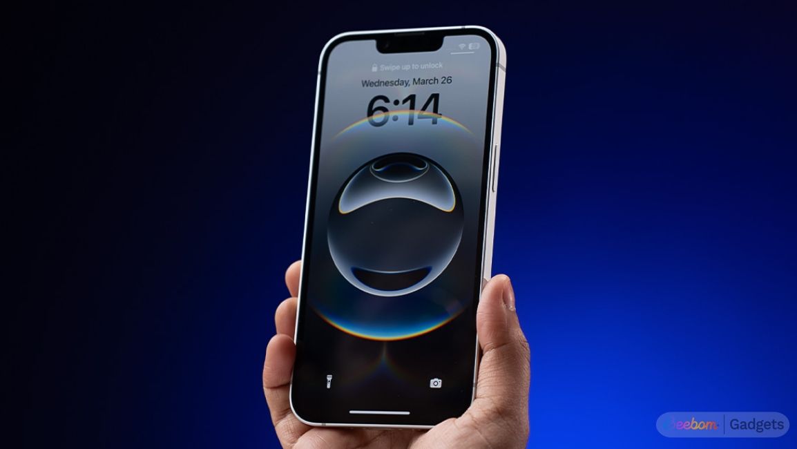 shot of a hand holding the iPhone 16e showing the iOS home screen shot of a hand holding the iPhone 16e showing the iOS home screen