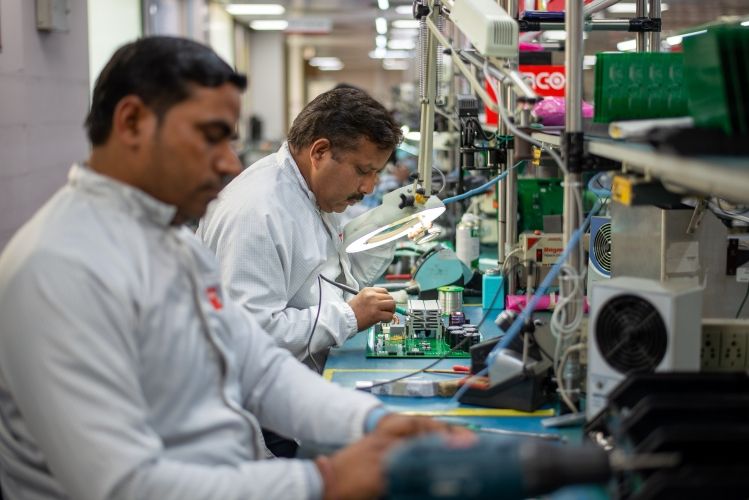 Two persons in an electronics assembly using soldering irons