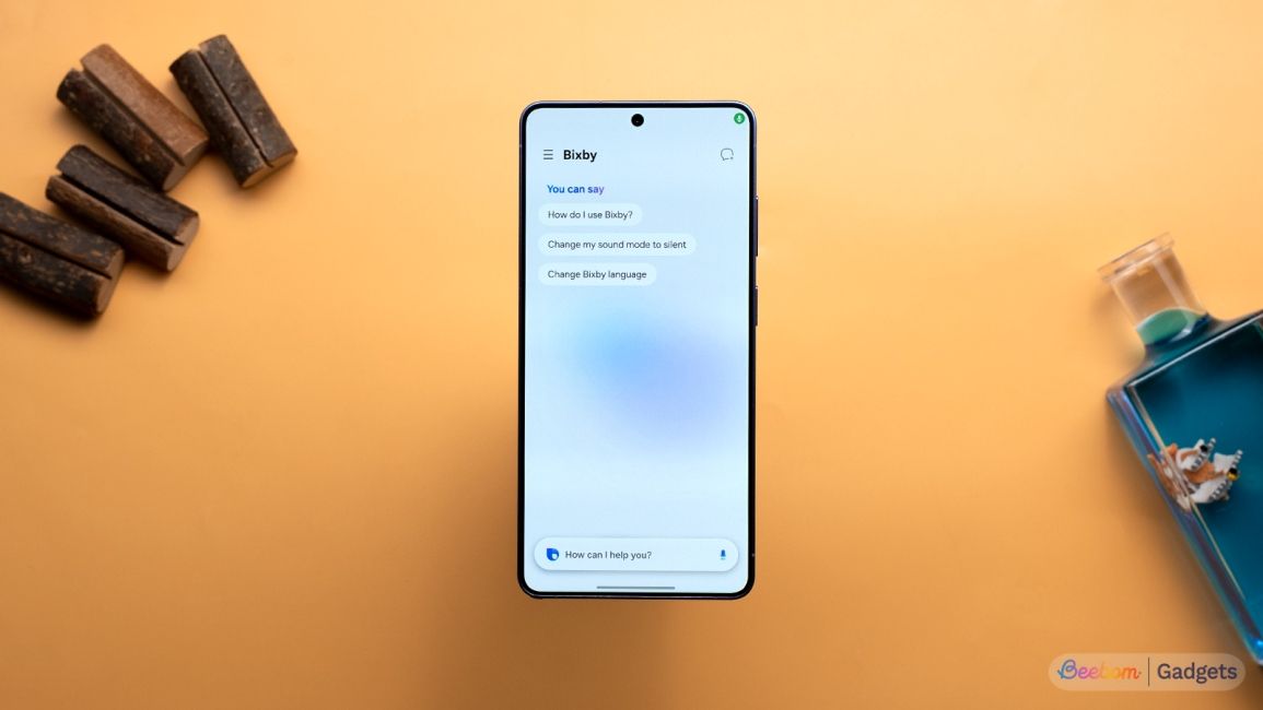 Samsung Galaxy S26 Ultra Bixby AI screen on the phone shown against an orange background