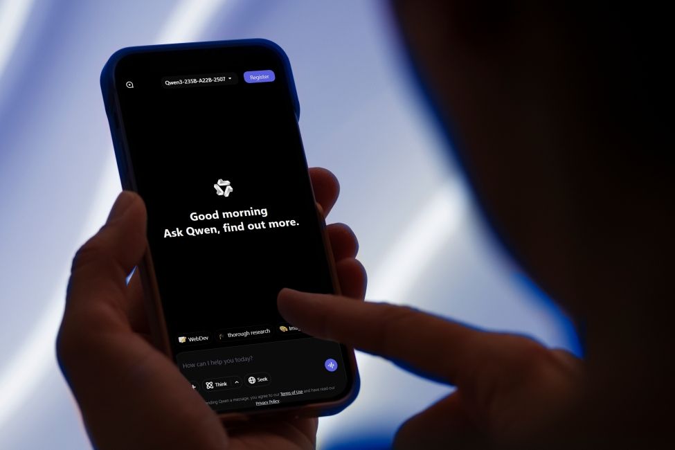 shot of a person interacting with a phone running Qwen AI app shot of a person interacting with a phone running Qwen AI app