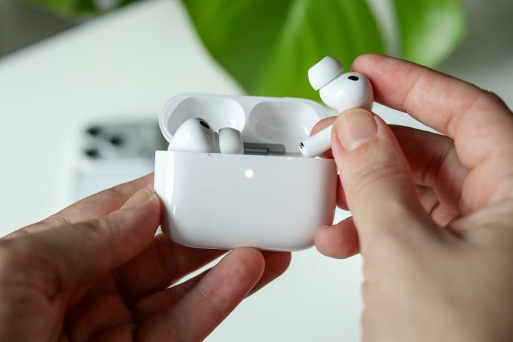 AirPods being put inside the case with white light AirPods being put inside the case with white light
