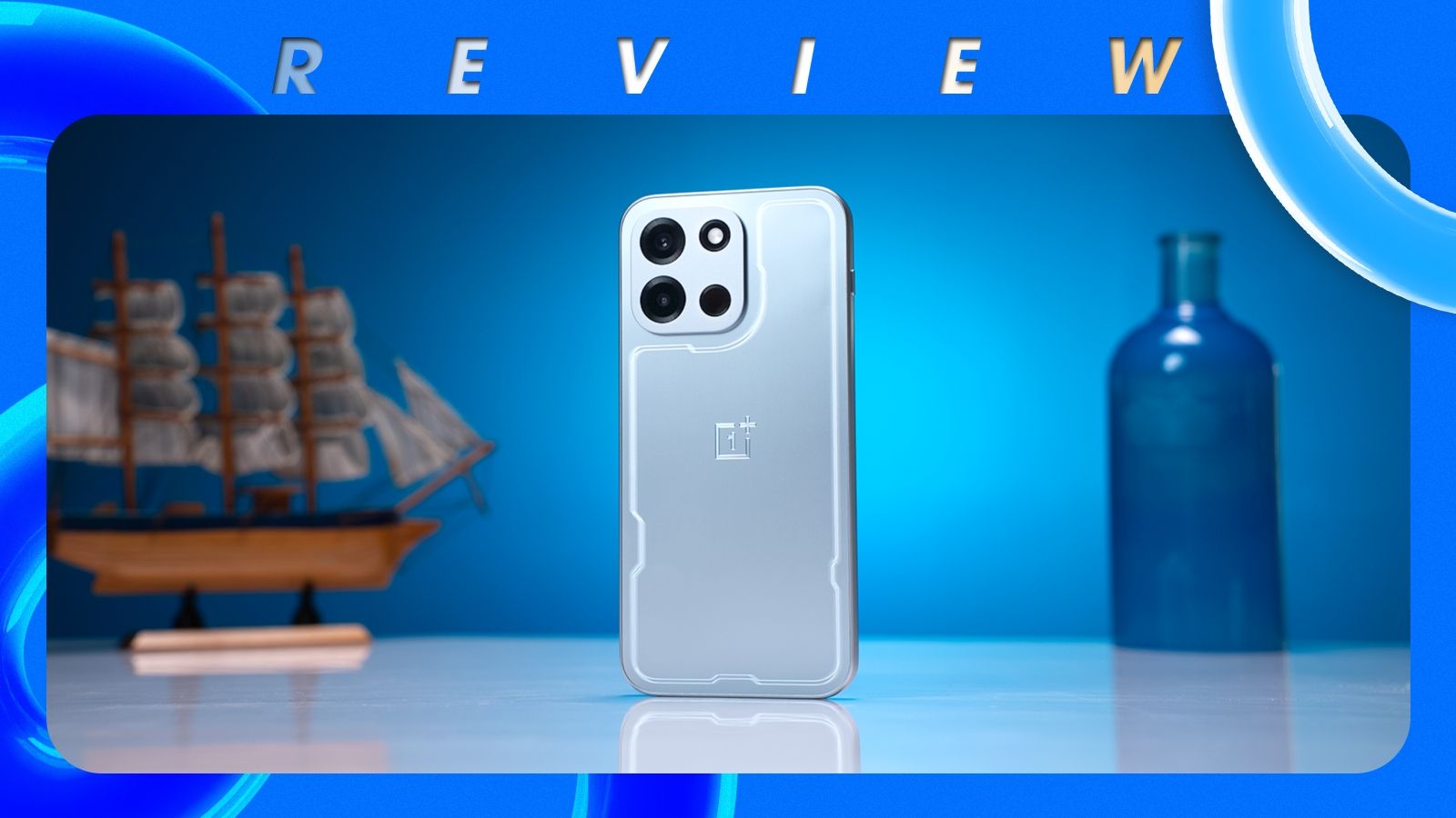 shot of the OnePlus Nord 6 standing upright on a desk in front of a blue background