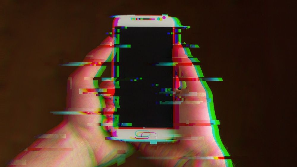 a person holding a phone, glitching effect on the image