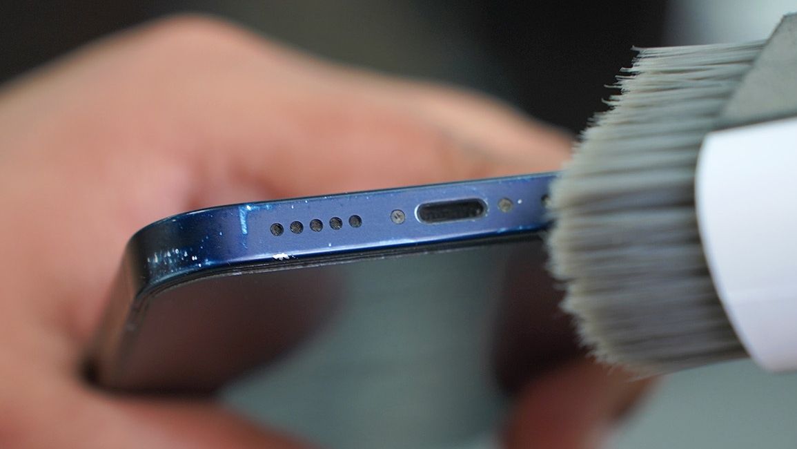 Cleaning-iPhone-Speaker-Grill-with-soft-bristle-brush