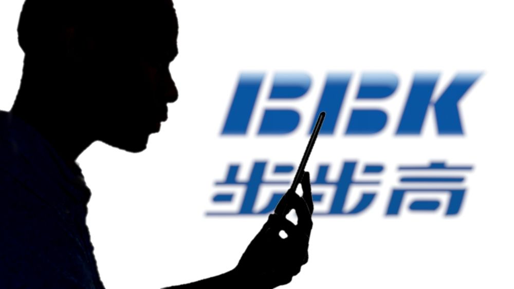 a person using a phone with BBK logo behind a person using a phone with BBK logo behind