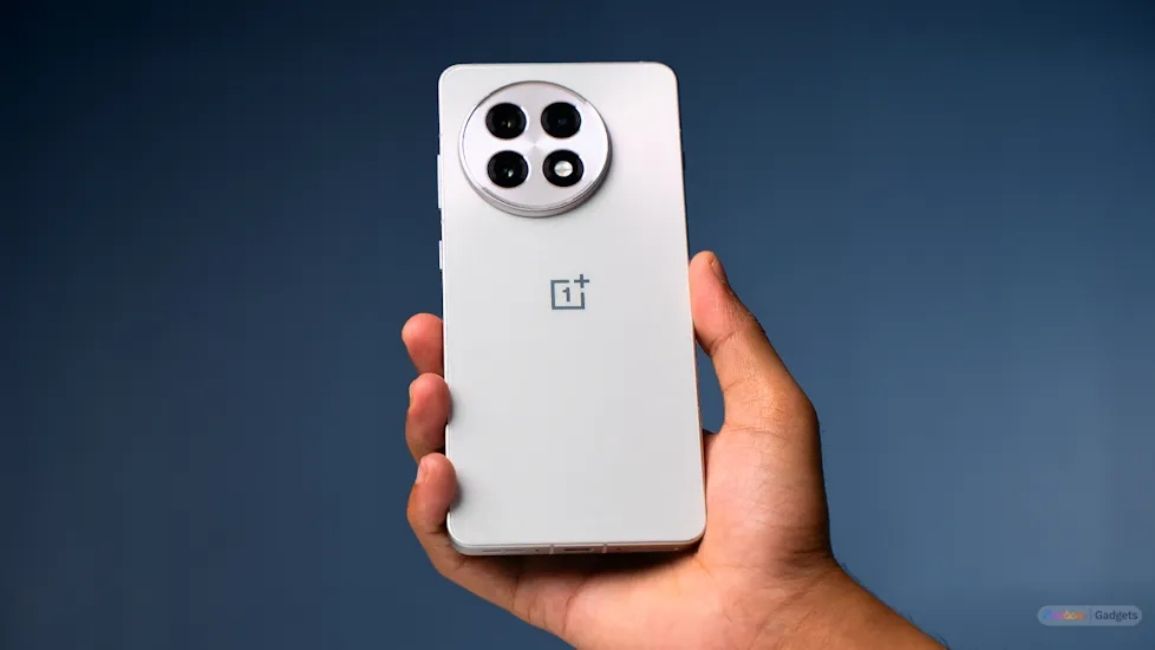 oneplus 13R in user's hand, blue background oneplus 13R in user's hand, blue background