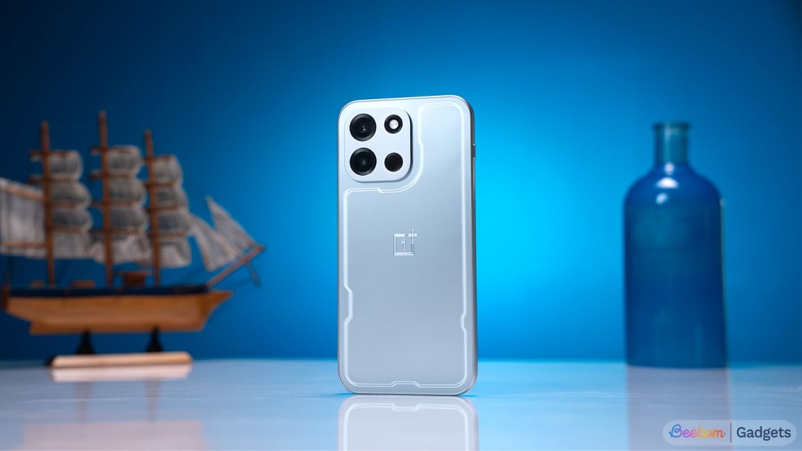 shot of OnePlus Nord 6 standing upright on a desk in front of a blue background