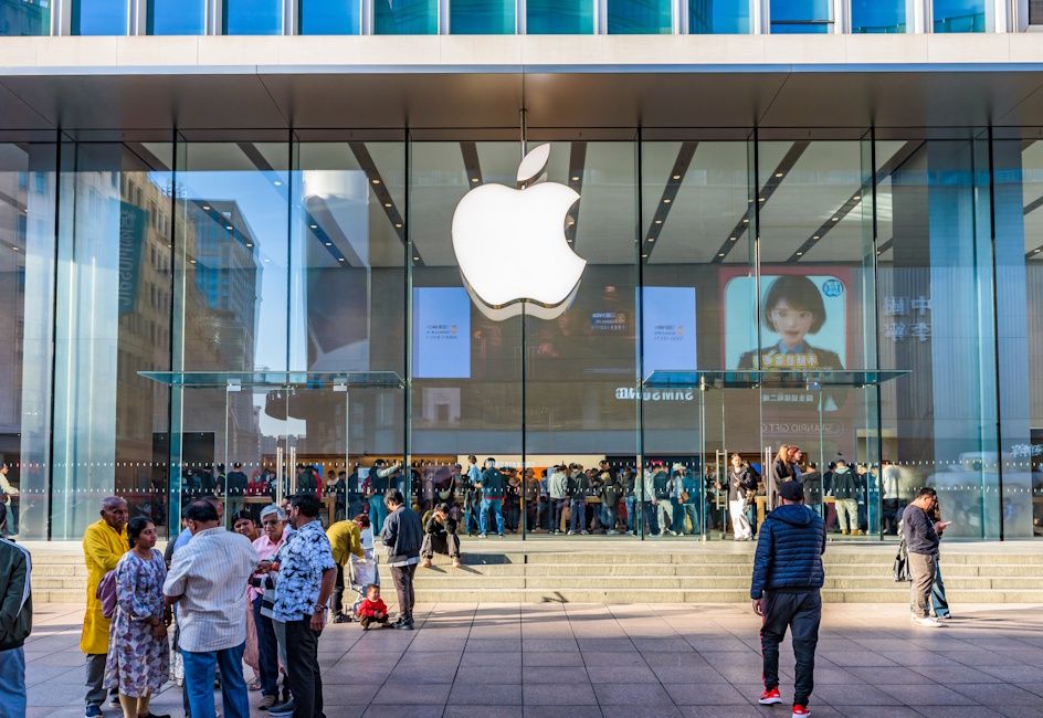 Apple store building at the back with a giant Apple logo and a lot of people near the building Apple store building at the back with a giant Apple logo and a lot of people near the building