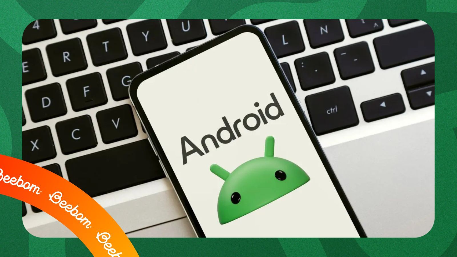 android logo on mobile, underneath laptop keyboard