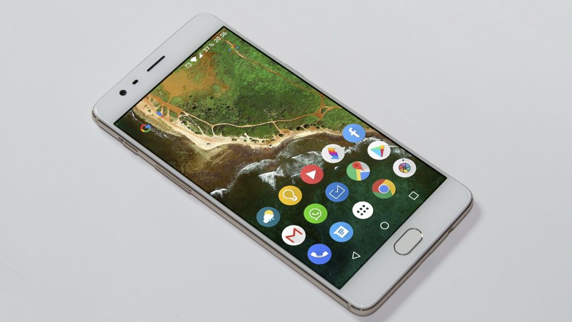 OnePlus 3 laying on a white background showing its homescreen OnePlus 3 laying on a white background showing its homescreen