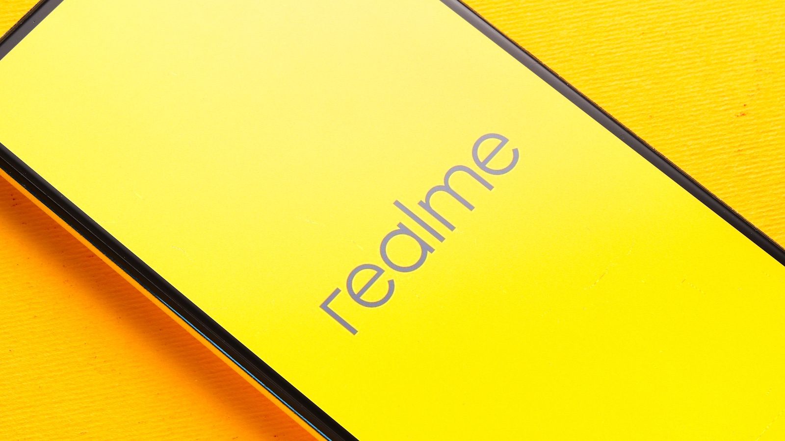 Realme official logo showcased on a Realme phone in a stock image