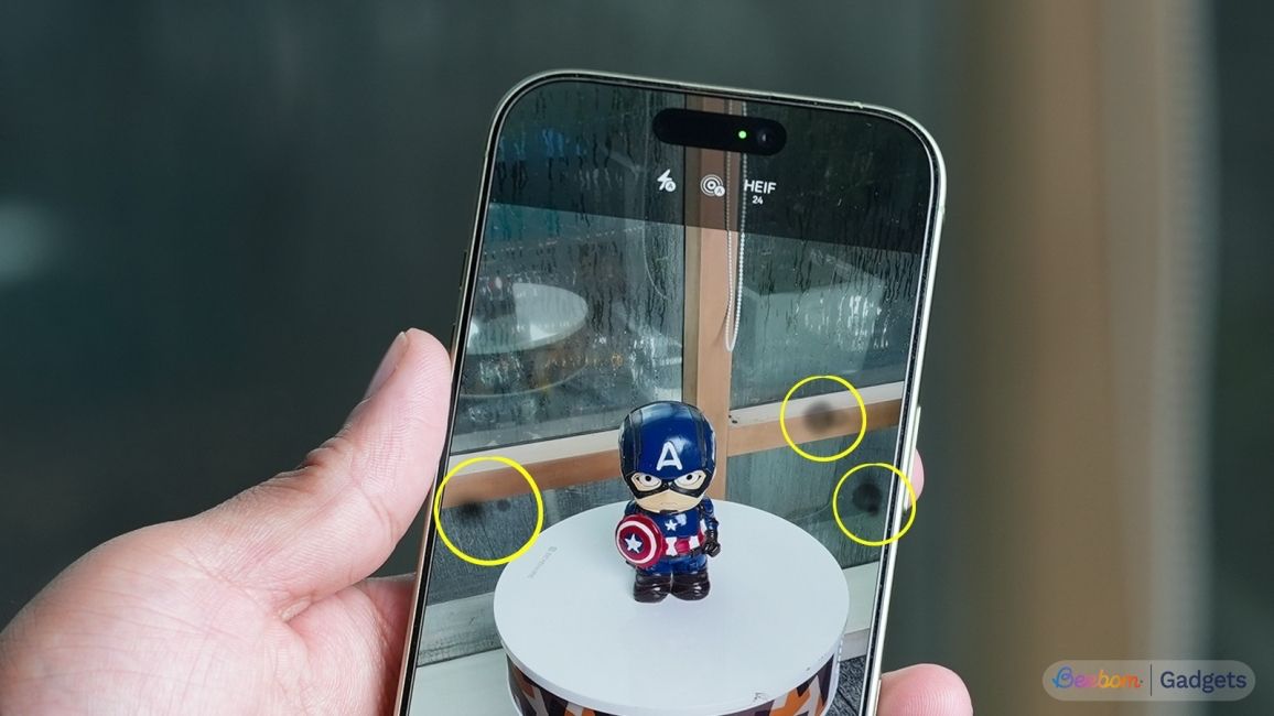 close up shot of an iPhone held in hand showing spots on camera viewfinder highlighted in yellow circles