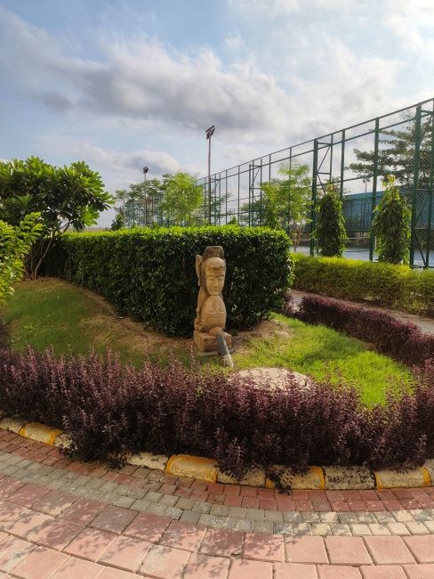 Image of a stone sculpture with colourful bushes around shot on Redmi Note 17 Pro Max main camera in daylight