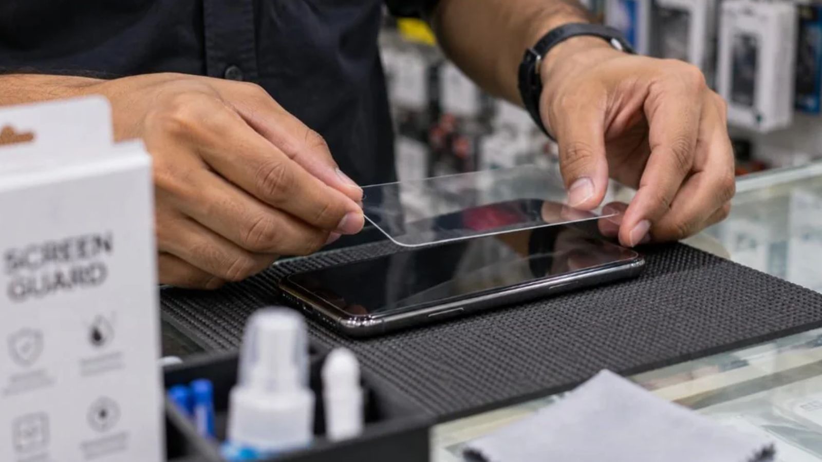 A man applying screen protector on a smartphone