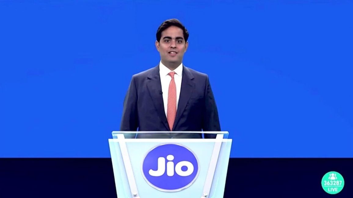 Aakash Ambani standing on a podium with Jio logo Aakash Ambani standing on a podium with Jio logo