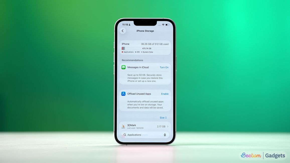 shot of iPhone standing upright on desk showing iPhone Storage screen inside iOS Settings app