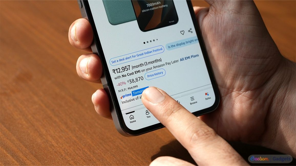 Finger pointing at a phone's EMI price and the actual price on the Amazon app