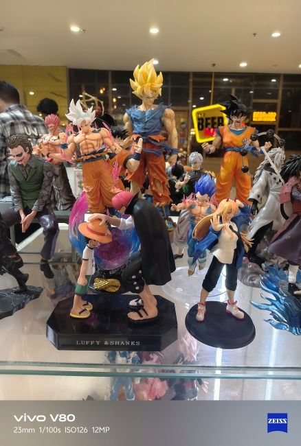 Anime miniatures on a platform shot on Vivo V80