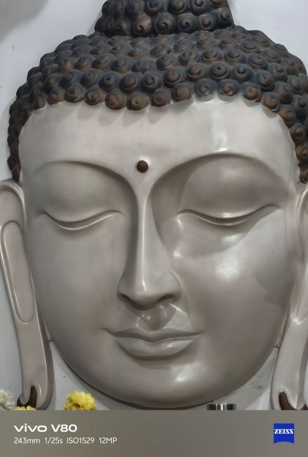 Closeup of Buddha icon on wall captured on Vivo V80's telephoto camera
