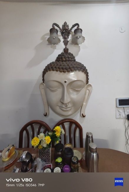 Ultrawide shot of wooden Buddha sculpture on a wall captured on Vivo V80