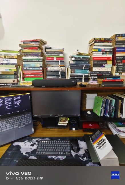Ultrawide shot of workdesk with books and computer captured on Vivo V80
